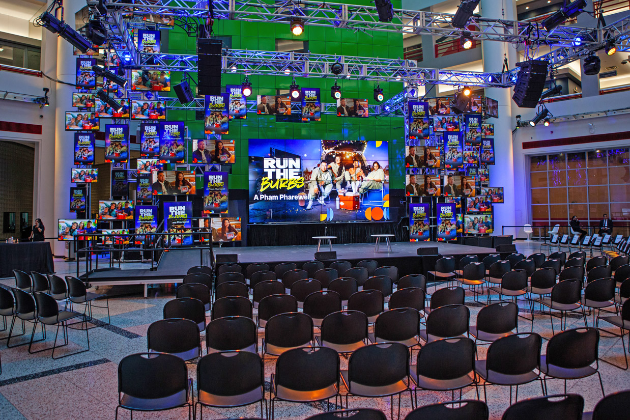 The CBC Barbara Frum Atrium stage with its multiple screens from behind the middle section of empty chairs.